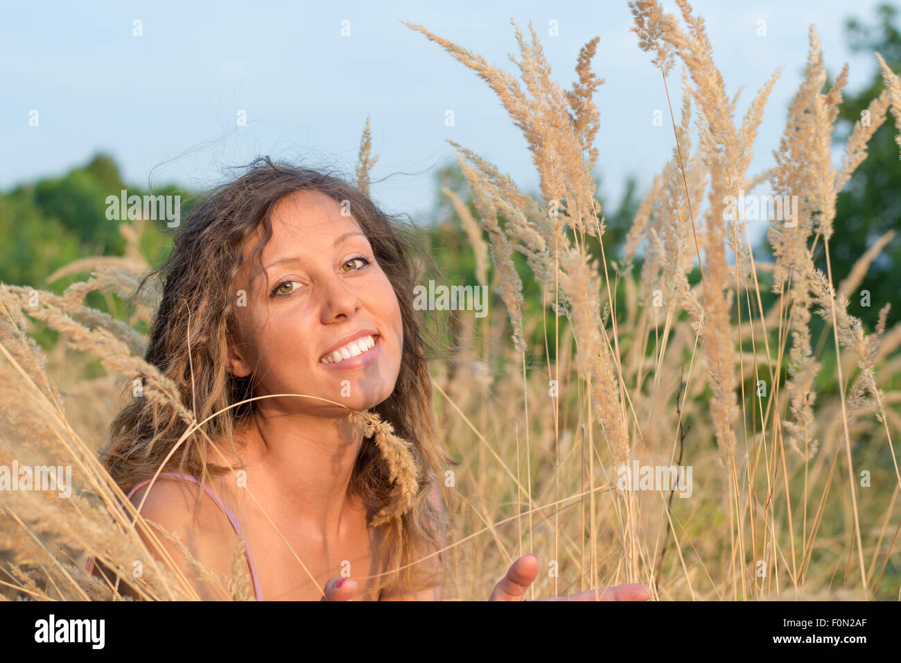 Porträt der hübsche Brünette Mädchen in die gelben Felder von getrockneten Blumen. Glückliches Mädchen im freien Stockfoto