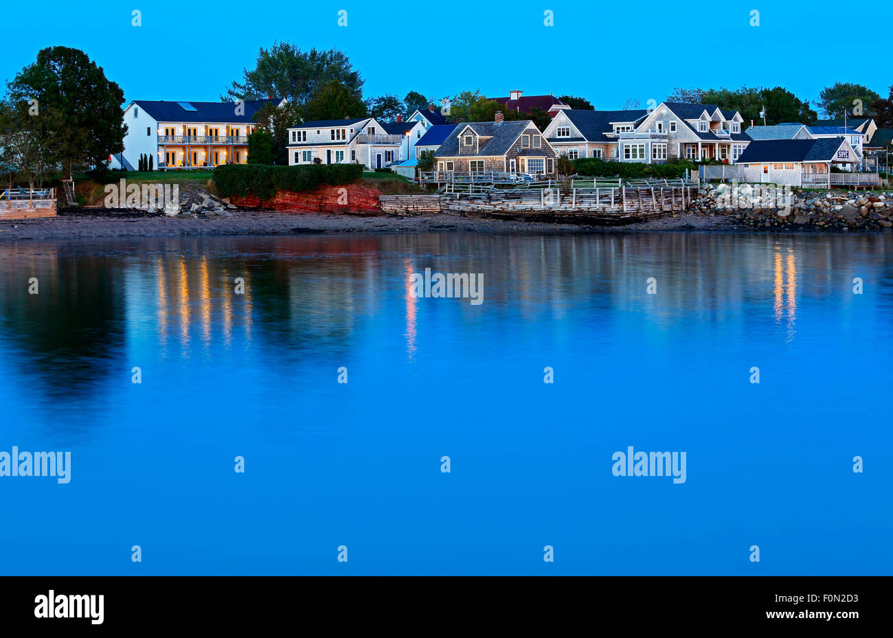 Twilight-Reflexionen von Gebäuden und Lichter am Ufer in Saint Andrews, New Brunswick, Kanada. Stockfoto
