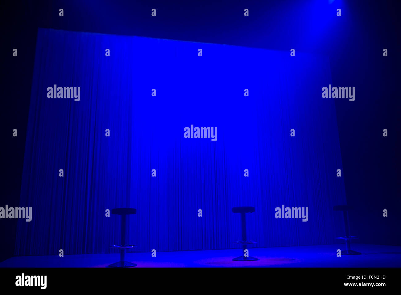 Blaue Bühne Strahler mit drei Hockern mit niemand Stockfoto