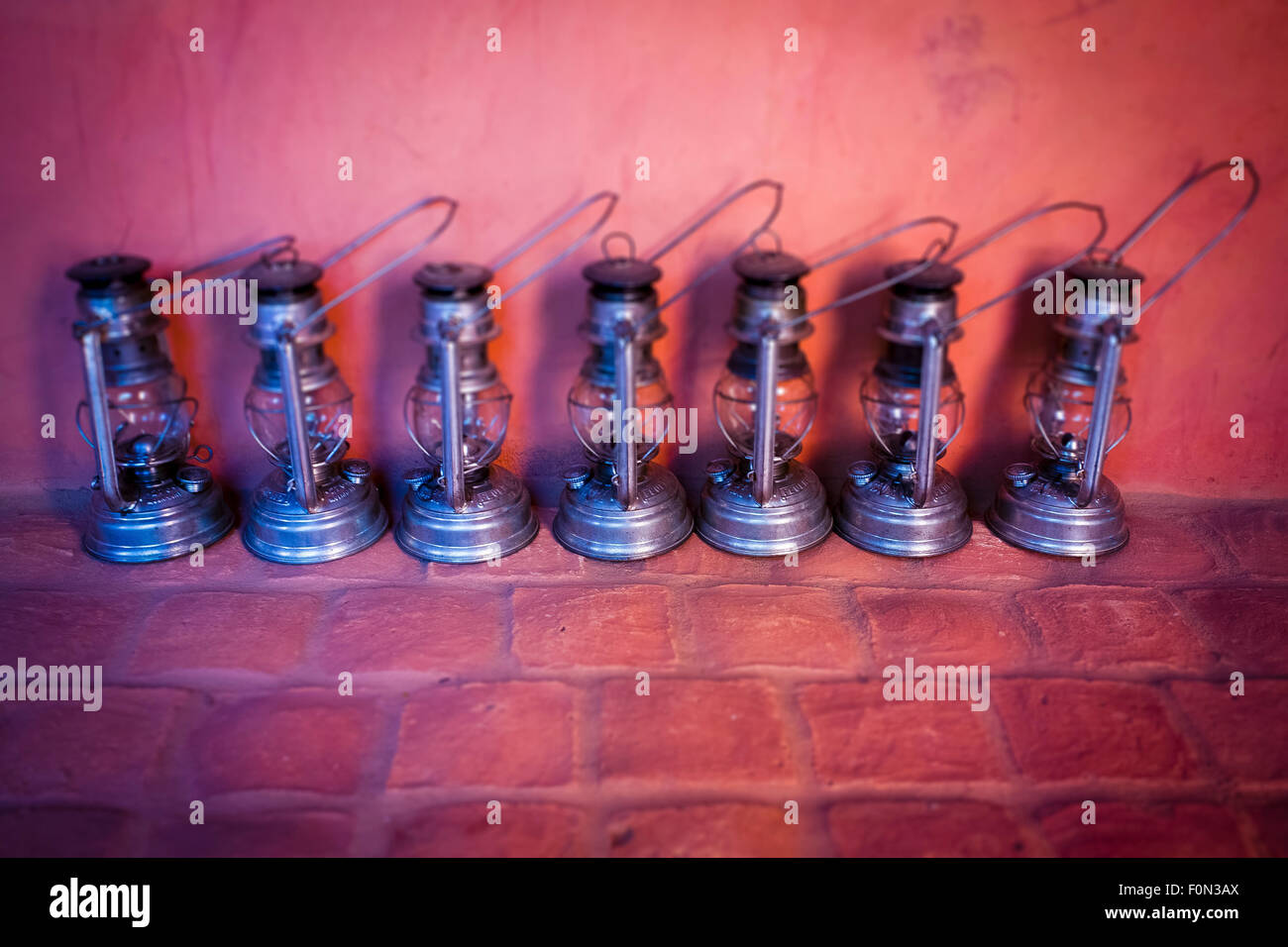 Sieben Metall Öllampen auf Wand Hintergrund gedreht Stockfoto