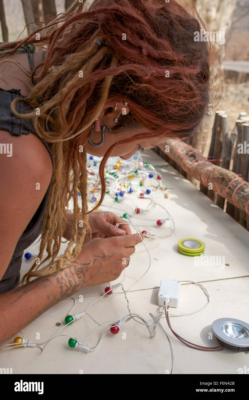 Unbekannte junge Frau, Mitglied der Gemeinschaft arbeiten an Beleuchtung Material. Mali 2011 Stockfoto