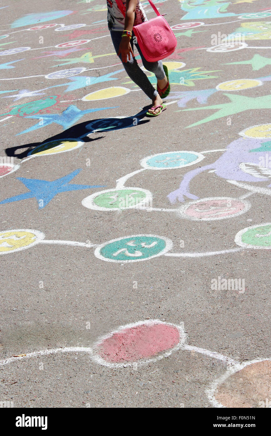 Kind, springen auf die kindlichen Zeichnungen als Spiel auf dem asphalt Stockfoto