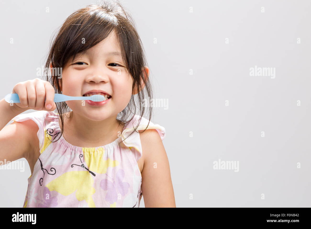 Süße Asiatin, Zähne putzen, weißen Hintergrund Studio isoliert. Stockfoto