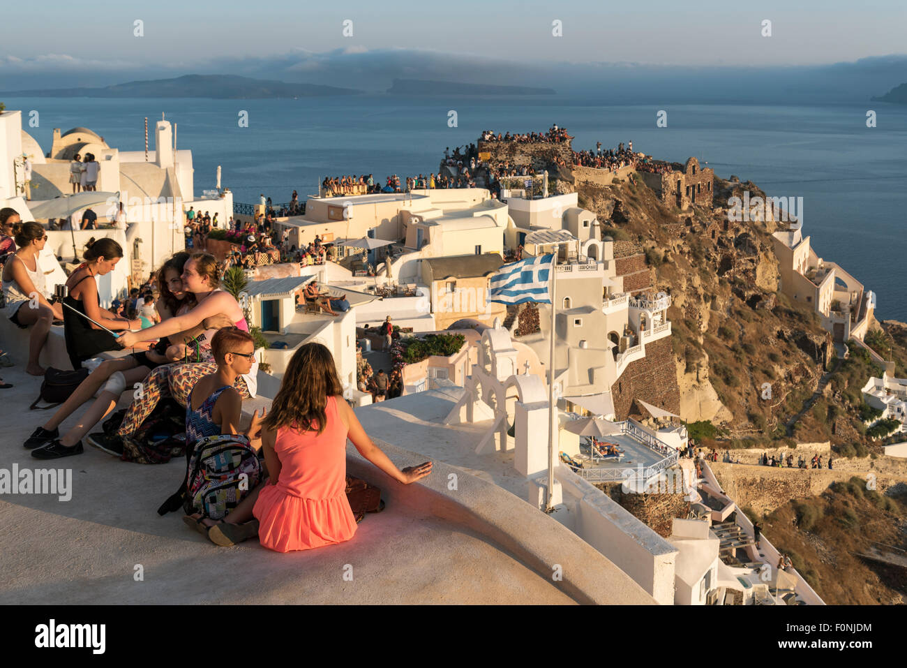 Touristen versammeln, um Uhr Sonnenuntergang von Kastelli (Burg) von Agios Nikolaos in Oia, Santorini, Griechenland Stockfoto