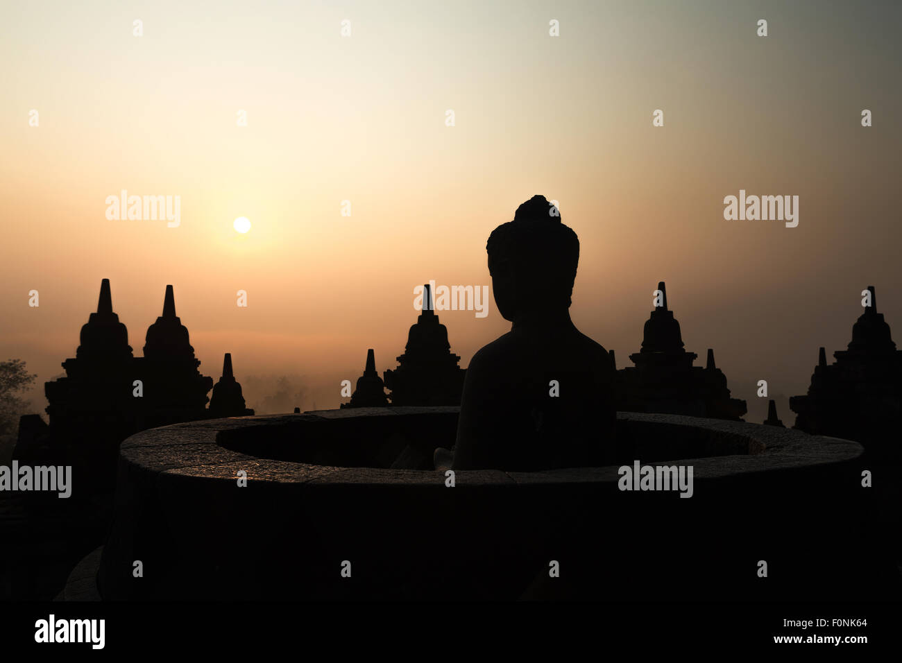 Silhouetten von einer Buddha-Statue auf der Unesco-Weltkulturerbe Website des Borobudur-Tempel in der Morgendämmerung auf der Insel Java, Indonesien, Asien. Stockfoto