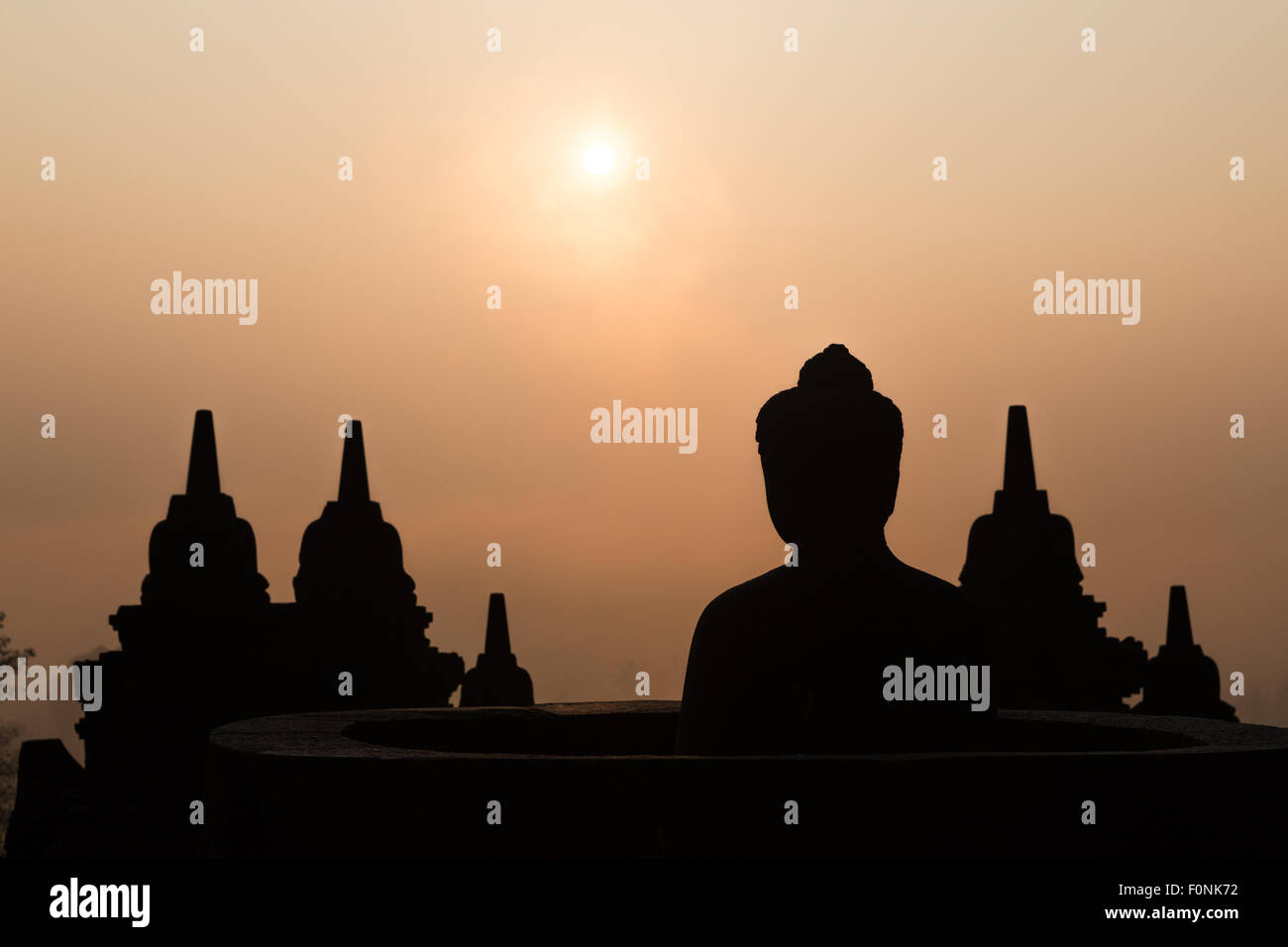 Silhouetten von einer Buddha-Statue auf der Unesco-Weltkulturerbe Website des Borobudur-Tempel in der Morgendämmerung auf der Insel Java, Indonesien, Asien. Stockfoto