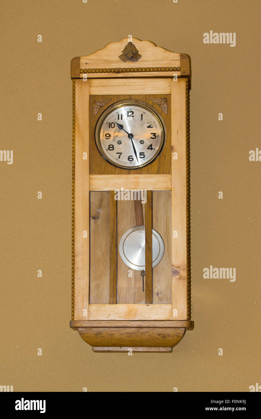 Eine Innenwand montiert traditionellen Stil Holzuhr mit Pendel und ein Gesicht mit Zahlen auf in einem Haus in Österreich. Konzept: Zeit Stockfoto
