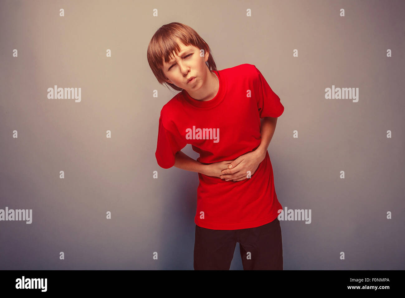 Junge Teenager zwölf Jahre im roten Hemd Abdominal-Schmerz, gastr Stockfoto