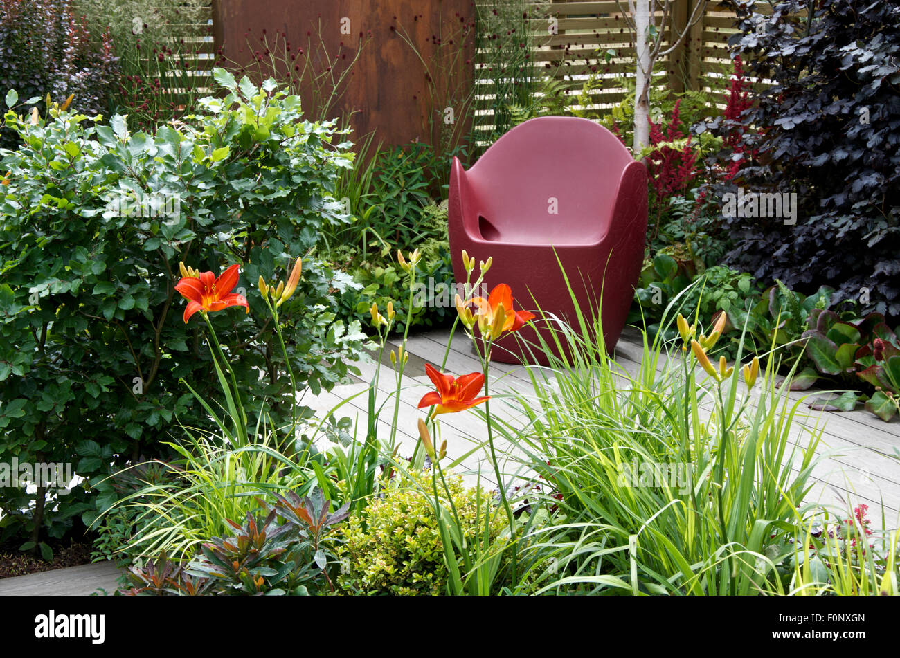 Tiefes rot Stuhl und kostenlose Bepflanzung in Grundlagen für Wachstum Garten am RHS Hampton Court Palace Flower Show 2015 Stockfoto