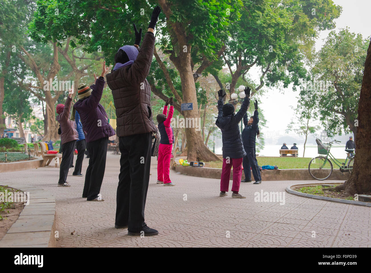 Tai Chi Park asia, Ansicht von Frauen mittleren Alters, die am frühen Morgen an einer Tai Chi Session am Hoan Kiem See in Hanoi, Vietnam teilnehmen. Stockfoto