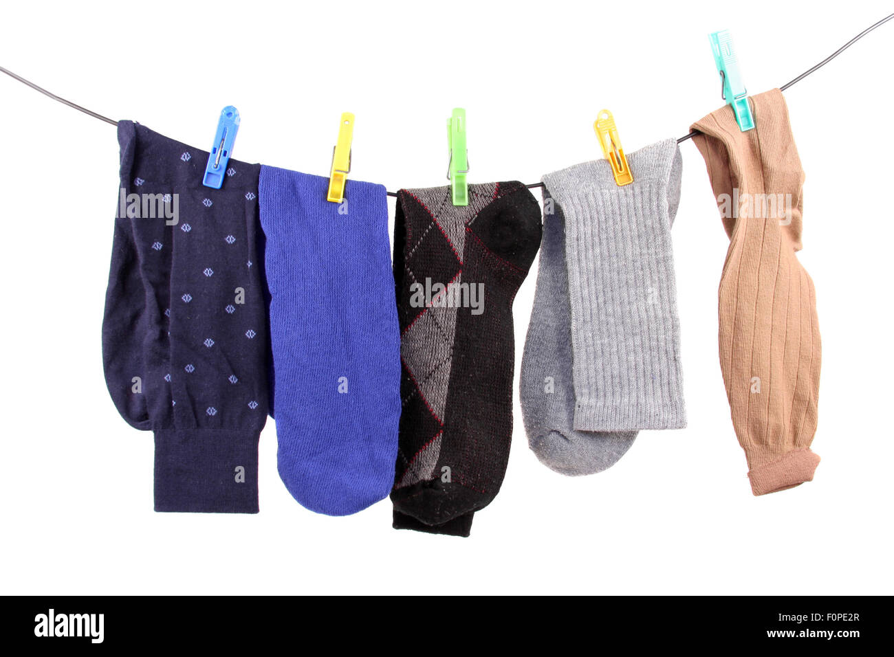 Einige Socken hängen von einer Wäscheleine isoliert auf weiss Stockfoto