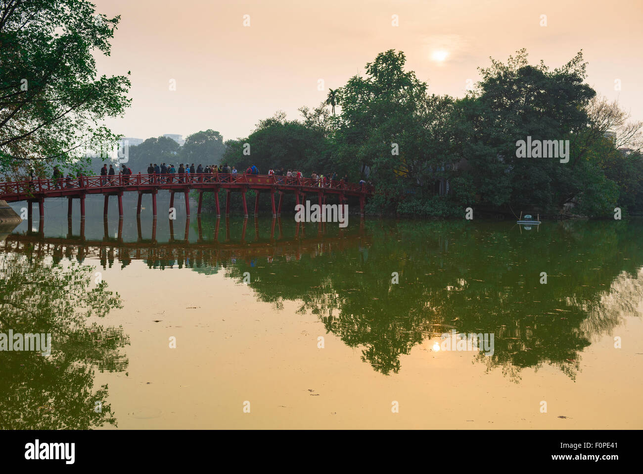 Hanoi Seebrücke, Blick bei Sonnenuntergang auf Touristen, die die Huc-Brücke auf dem Hoan Kiem See überqueren, um den Tempel des Jade Mound, Vietnam, zu besuchen Stockfoto