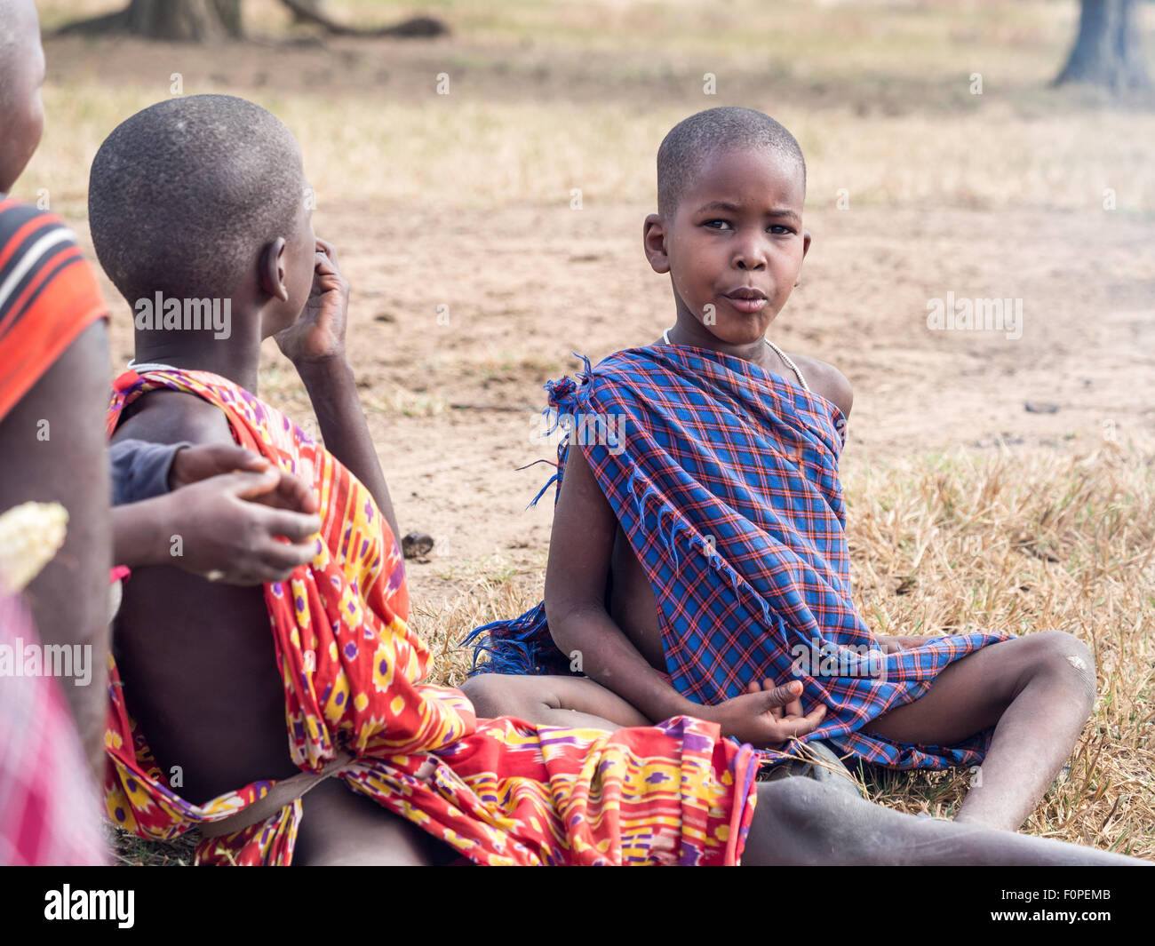 Maasain Kinder sitzt neben einem Feuer in ihrer Boma (Dorf) in Tansania, Afrika. Stockfoto