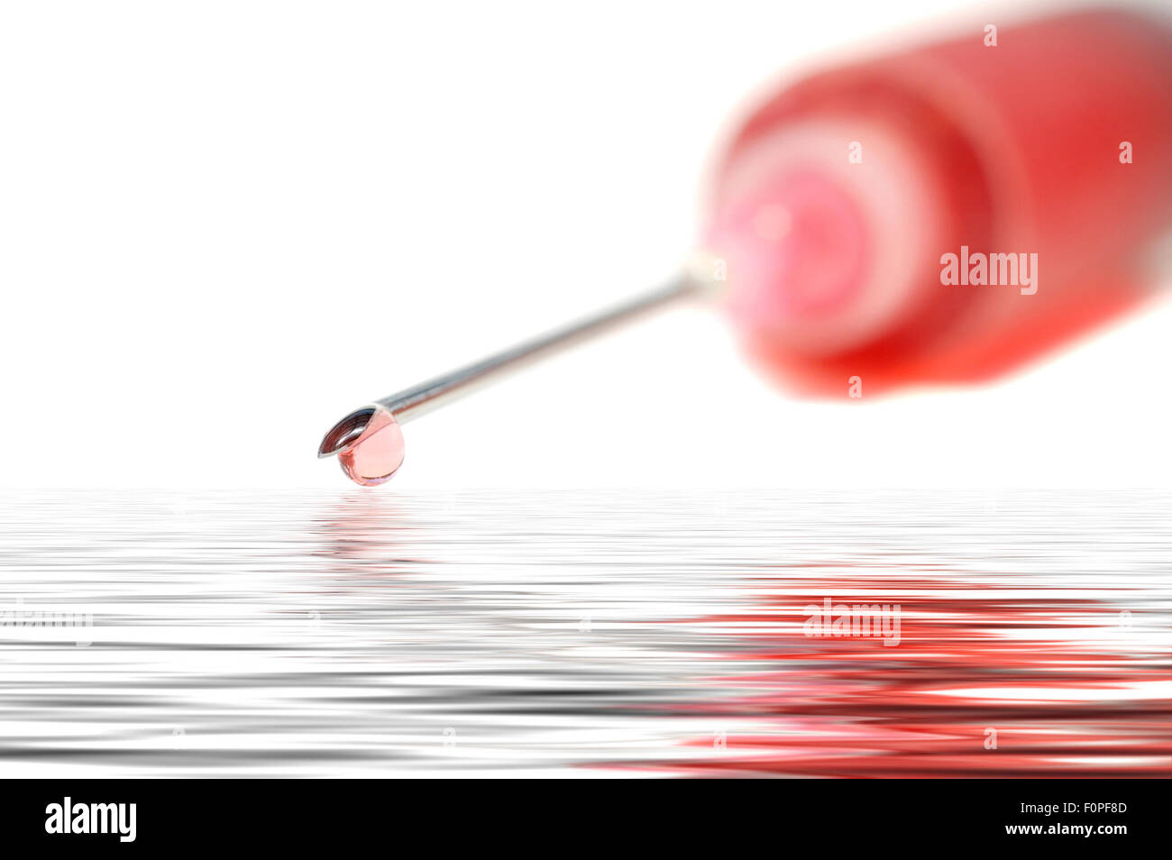 Spritze mit roter Flüssigkeit isoliert und in einer Flut Stockfoto