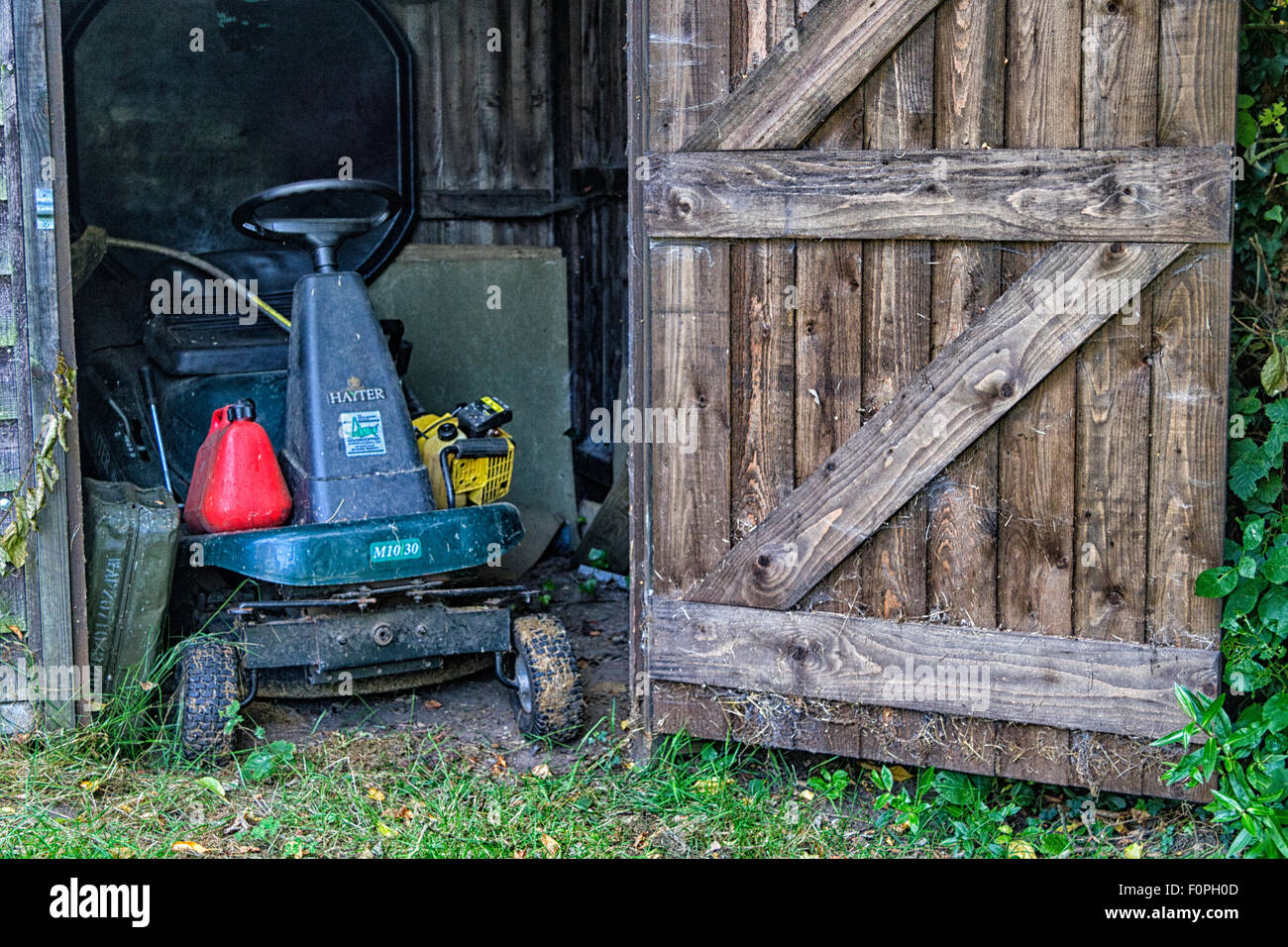 Fahrt auf Mäher in einem hölzernen Schuppen gespeichert Stockfoto