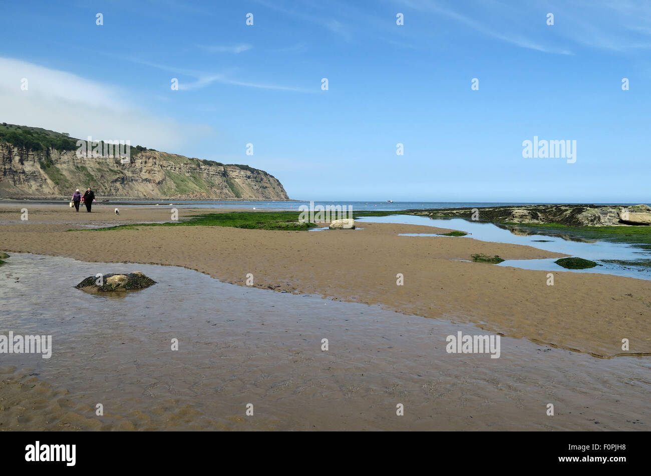 Zwei Menschen gehn an Robin Hood Bay einsamen Strand. Robin Hood Bay, North Yorkshire, UK. Stockfoto