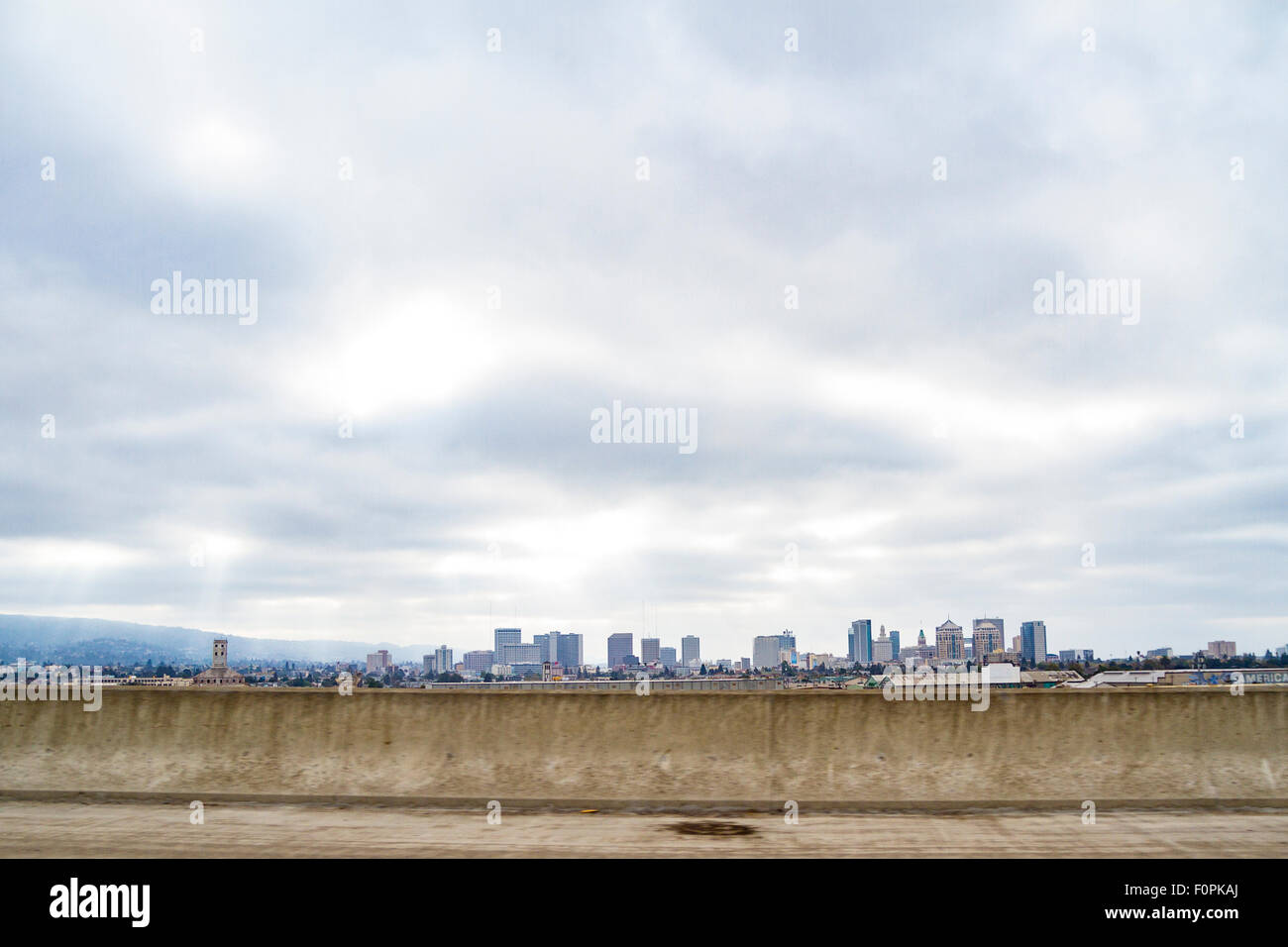 Die Innenstadt von Oakland Kalifornien an einem bewölkten Tag mit Sonnenlicht streaming über den Wolken Stockfoto