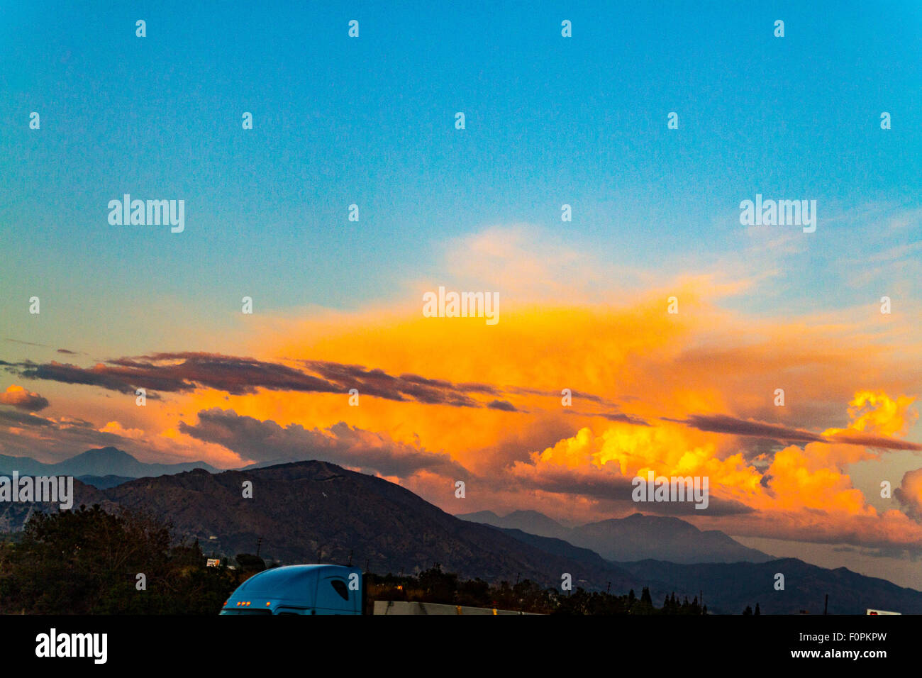 Ein flammendes orange Wolke über den San Gabriel Mountains im südlichen Kalifornien bei Sonnenuntergang Stockfoto