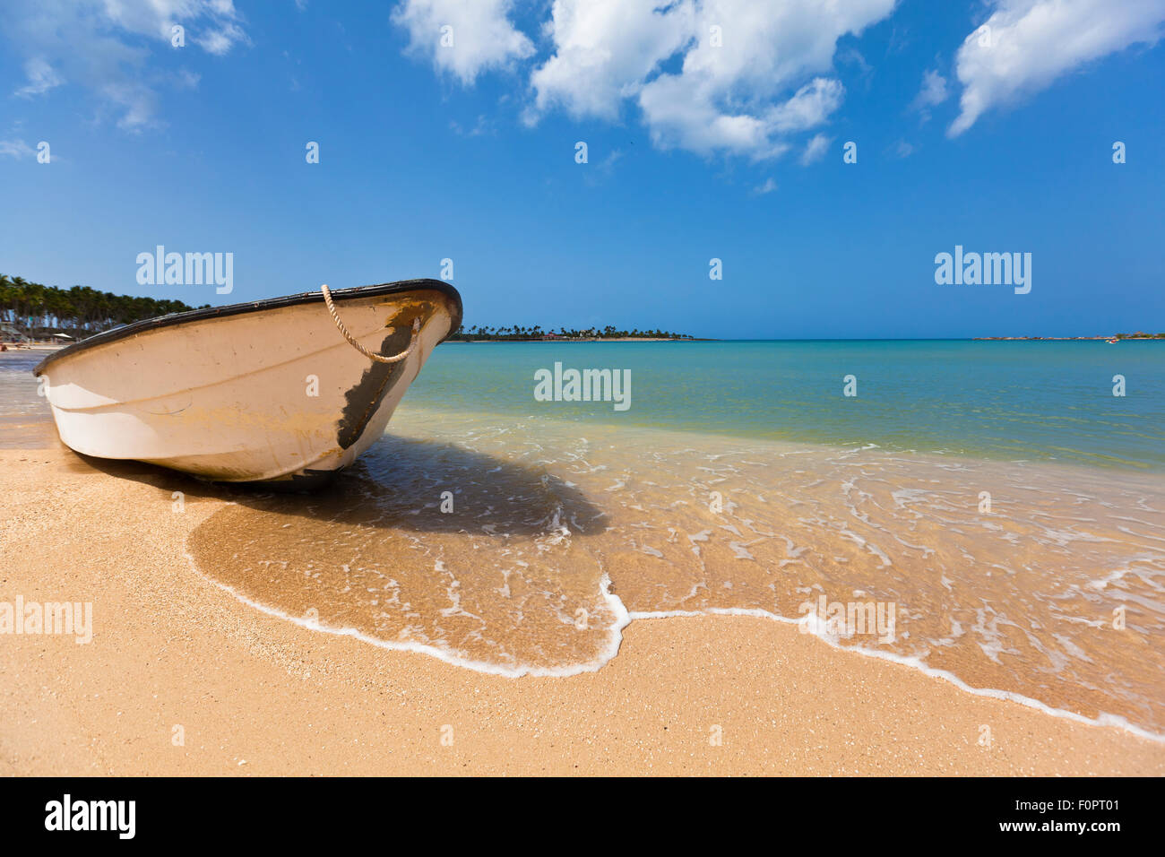 Ein Boot sitzen gestrandet auf Punta Cana an der Karibik mit strahlend blauen Wasser und Himmel strecken sich in den Horizont Stockfoto
