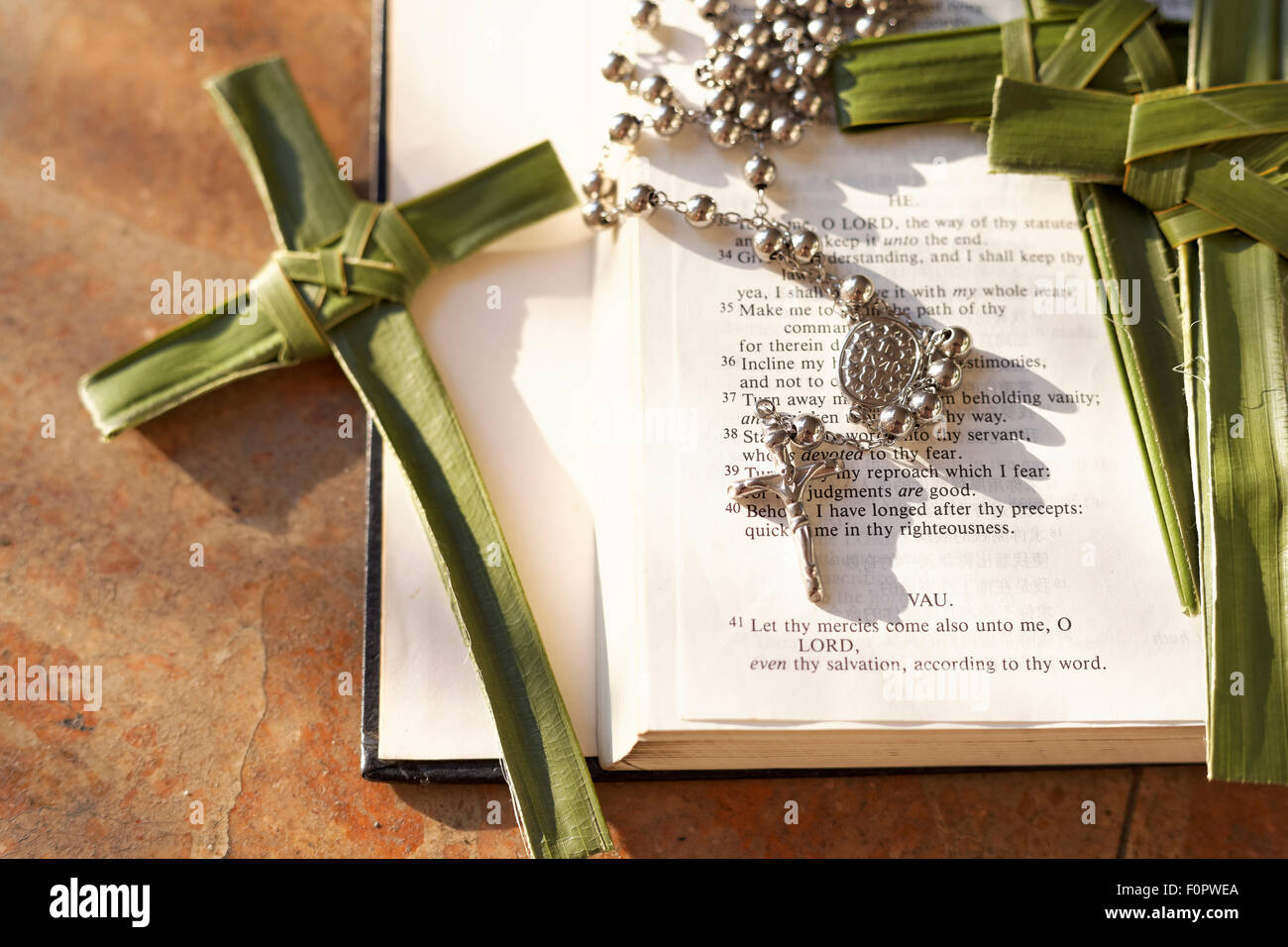 Palm, Kreuze und Rosenkränze auf eine Bibel Stockfoto