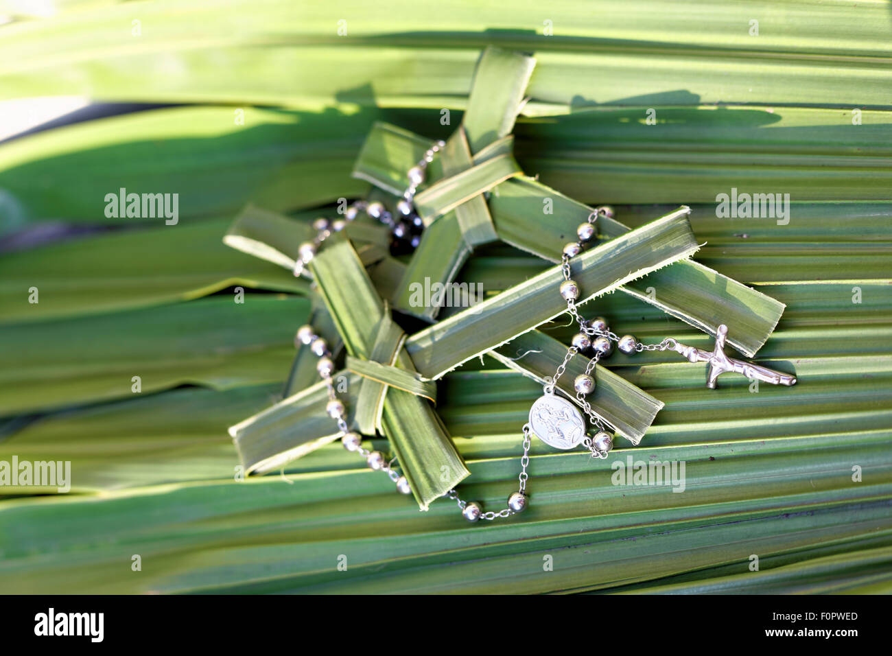 Palm kreuzt mit Rosenkranz Stockfoto