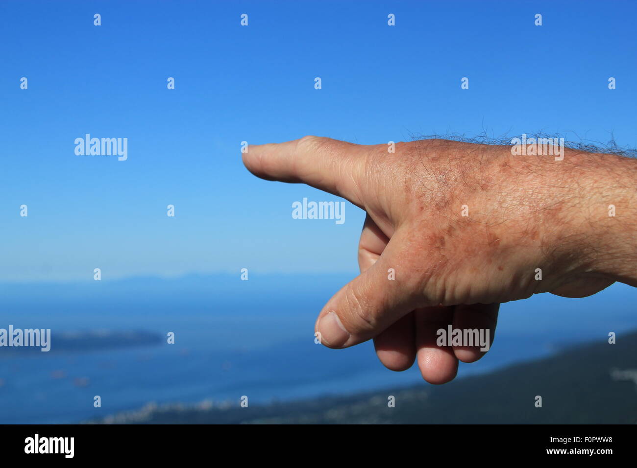 Die Hand des Mannes, der in der Entfernung als Symbol für die Zukunft, die Richtung und das Unbekannte Stockfoto