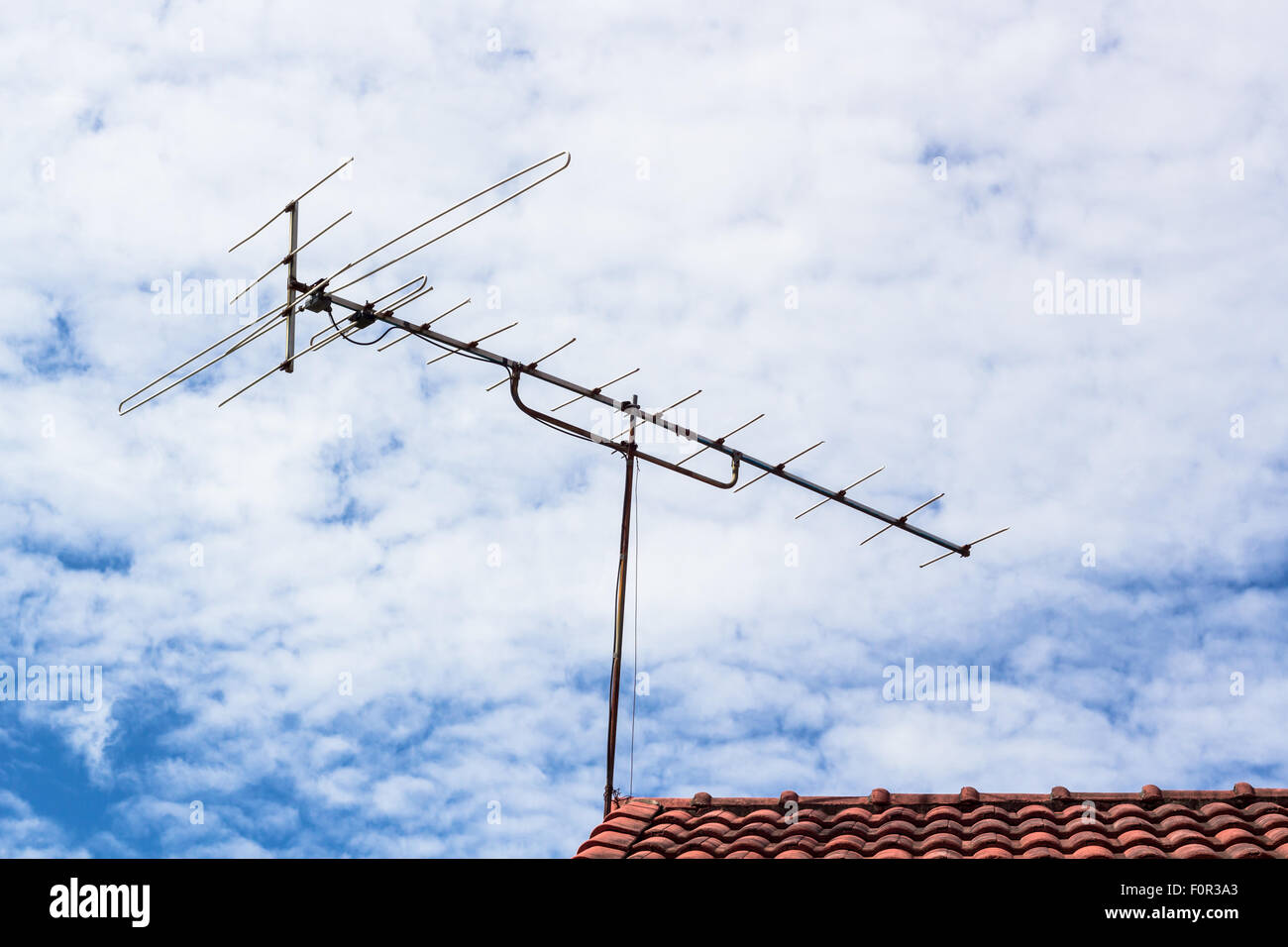 Outdoor-alte TV-Antenne auf dem Dach mit bewölktem Himmel Stockfoto