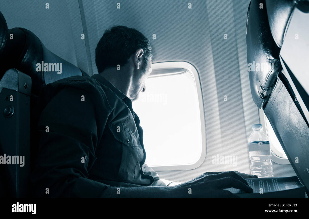 Reifer Mann in Fensterplatz im Flugzeug sitzen. Stockfoto