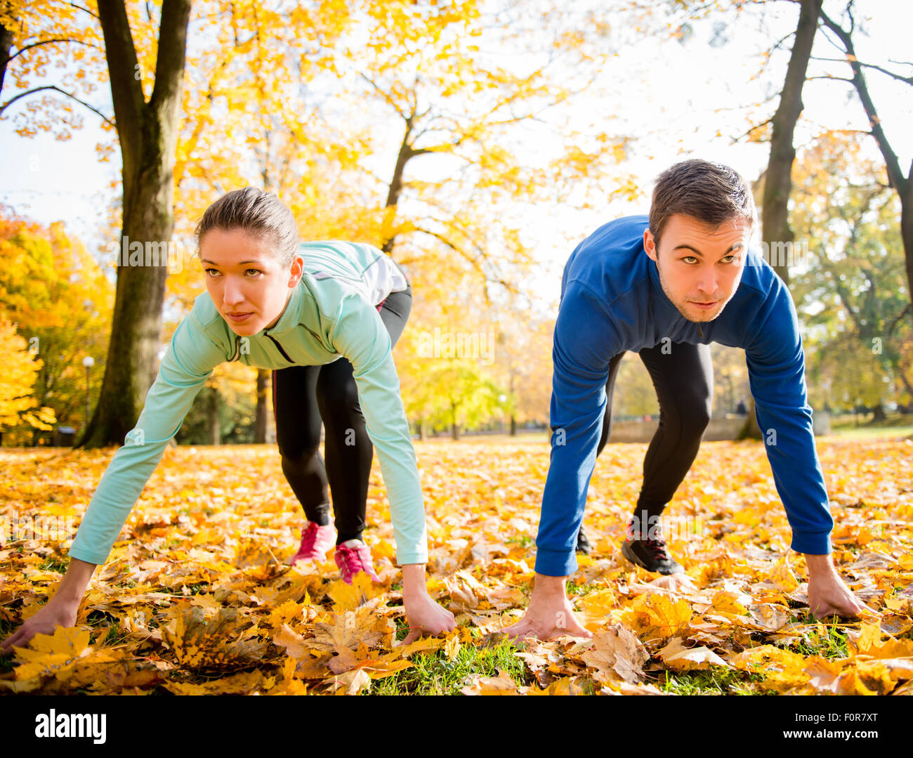 Junges Paar in der Ausgangsposition für den Betrieb im Herbst Natur vorbereitet Stockfoto