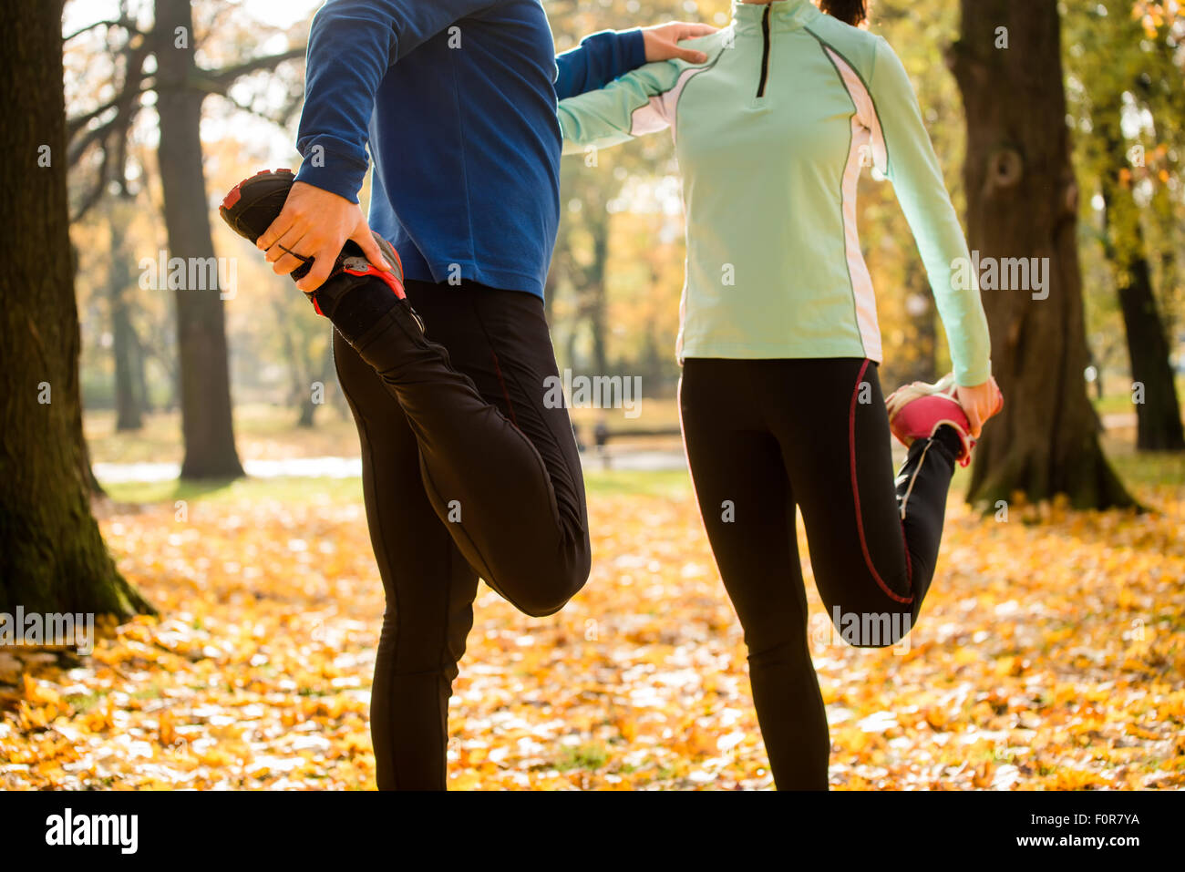 Detail von Mann und Frau dehnen Beine vor dem Joggen im Herbst Natur Stockfoto