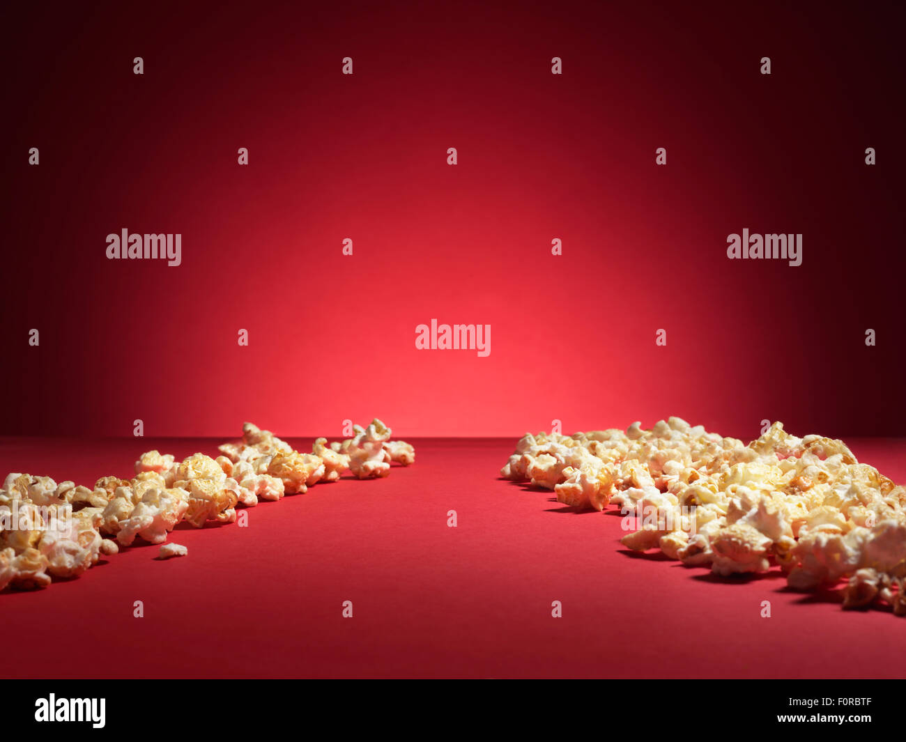 Schuss von Kino Stil Popcorn auf einem roten Hintergrund mit Spotlight und Kopie Raum. Stockfoto