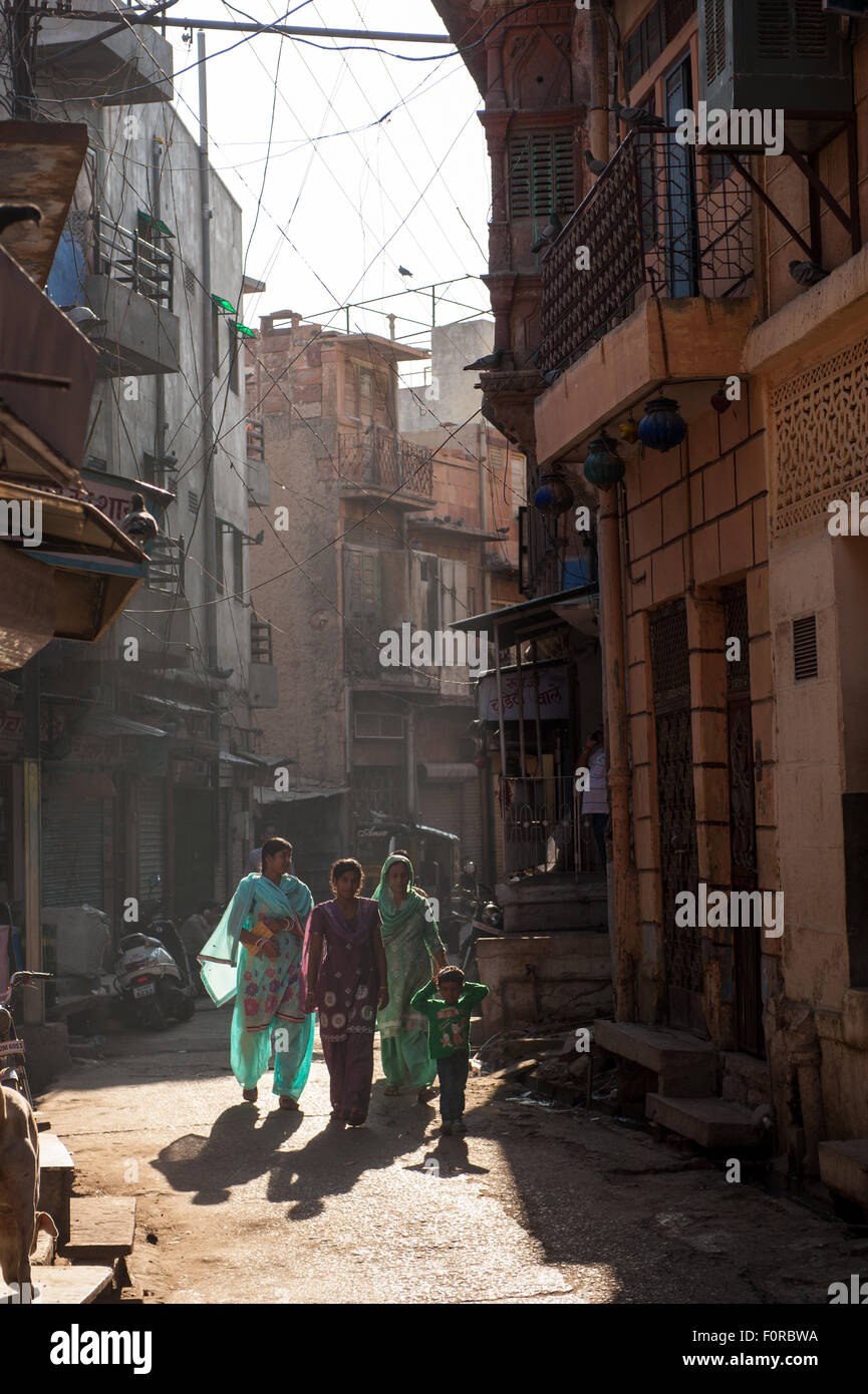 Jodhpur, Indien. Straßenszene mit drei Frauen in Saris und ein Junge. Stockfoto