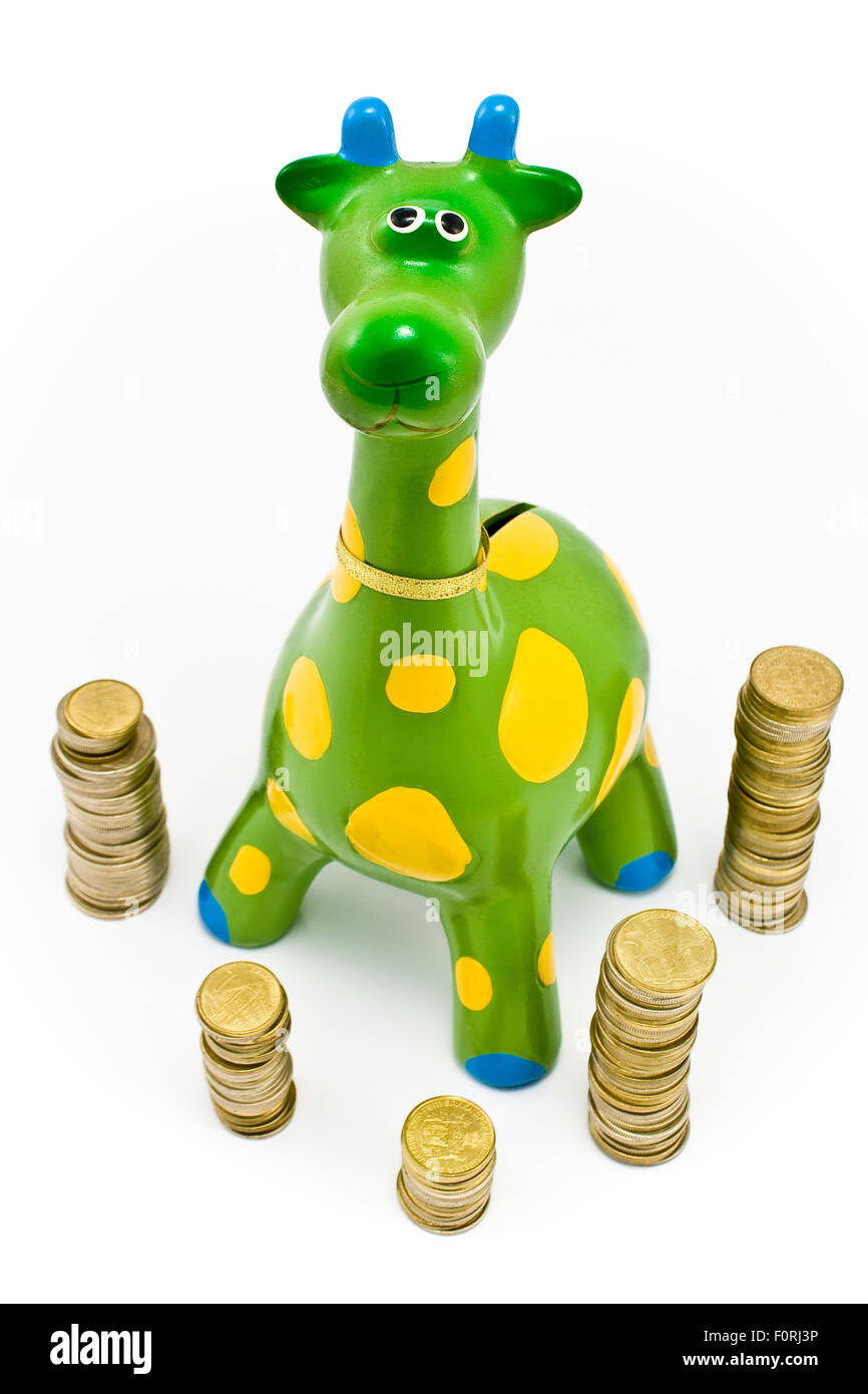 Giraffe-Spardose umgeben von Türmen der Münzen Stockfoto