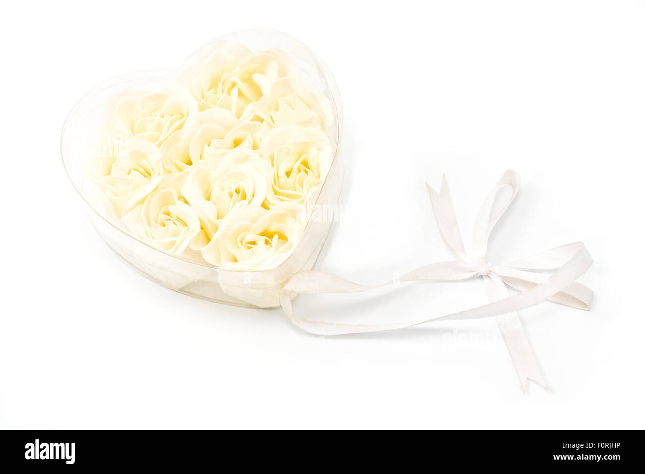 Weiße Rosen in transparenten Herz mit Schleife Stockfoto