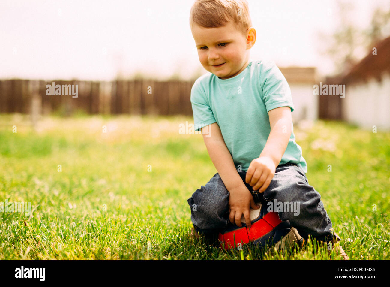 Entzückende kleine Jungen spielen mit einem Fußball im freien Stockfoto