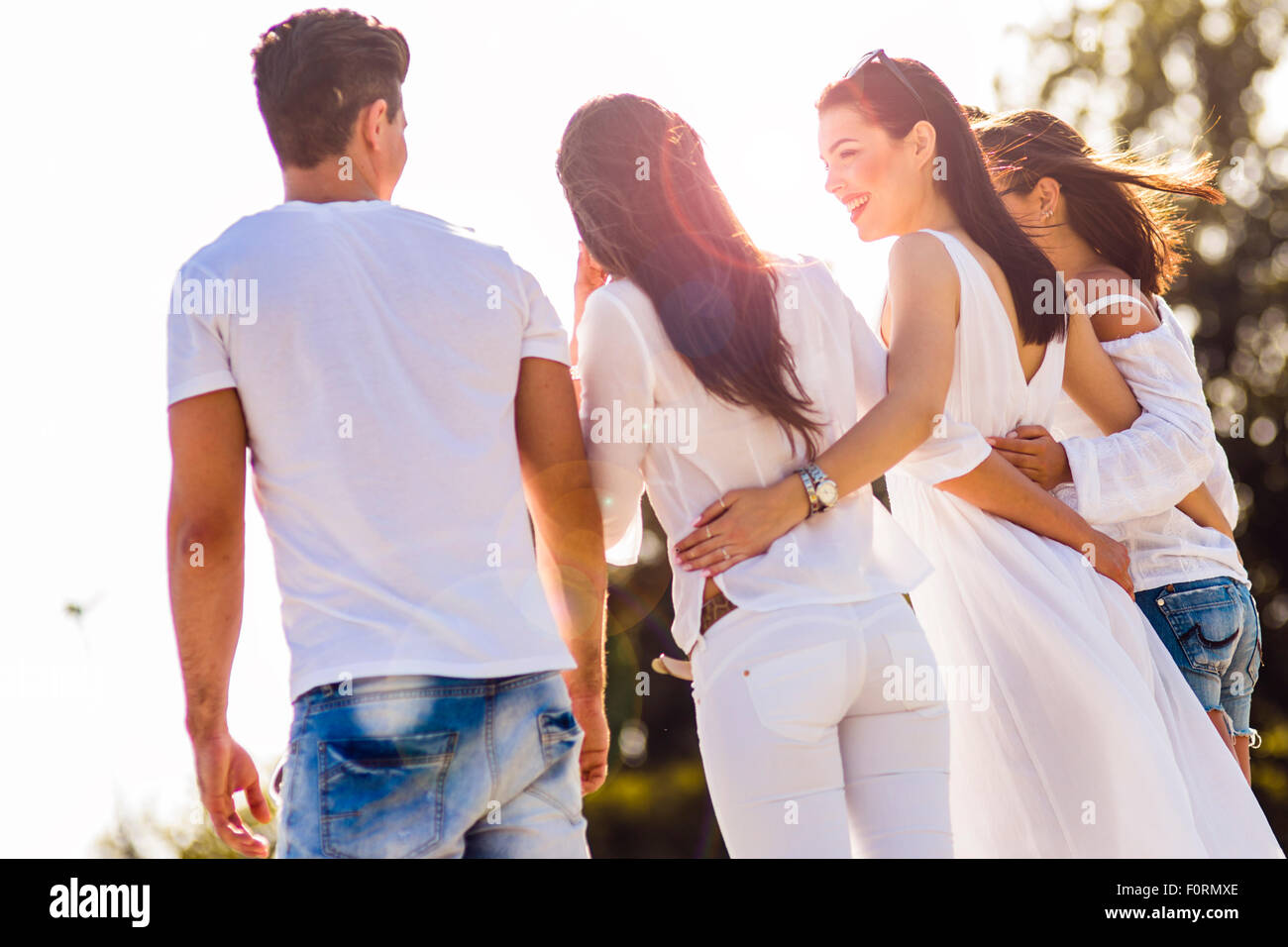 Gruppe von Jugendlichen, die Hand in Hand am Strand als Zeichen der Freundschaft Stockfoto