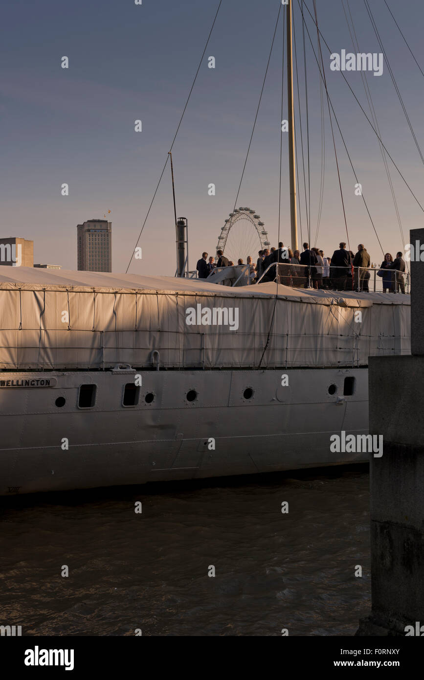 Gäste an Bord der HQS Wellington vertäut einem privaten Veranstaltungsort auf der Themse in London Stockfoto