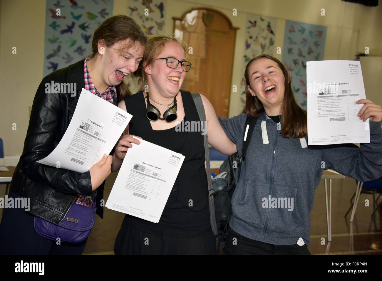 Eine Gruppe von Mädchen im Teenageralter hält ihre GCSE-Prüfungsergebnisse an Kamera und sehr zufrieden mit sich selbst suchen. Stockfoto
