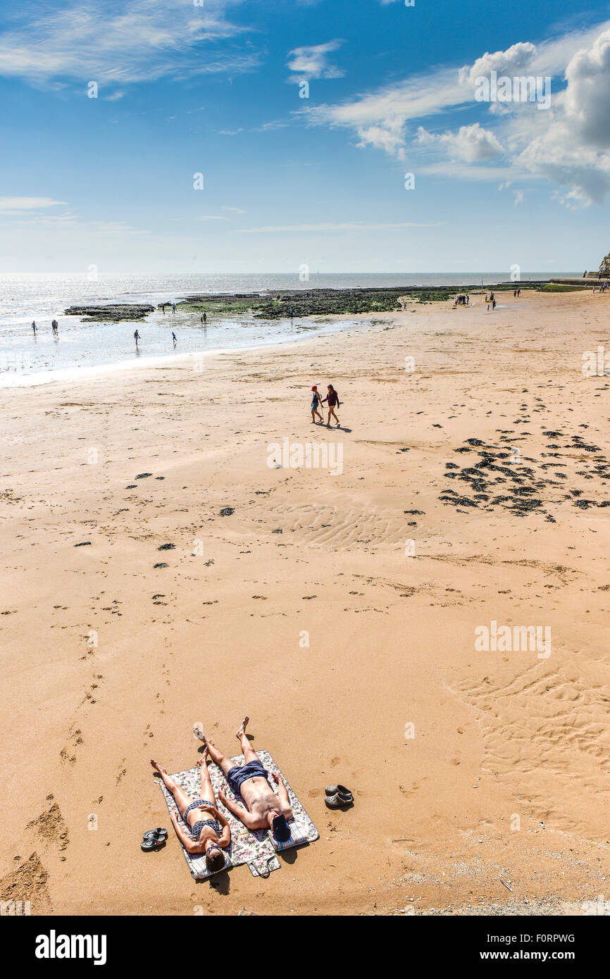 Sonnenanbeter am Strand in Broadstairs in Kent. Stockfoto