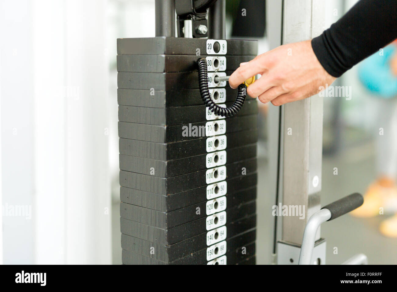 Nahaufnahme eines jungen Mannes, der das Gewicht während der Arbeit aus Auswahl Stockfoto