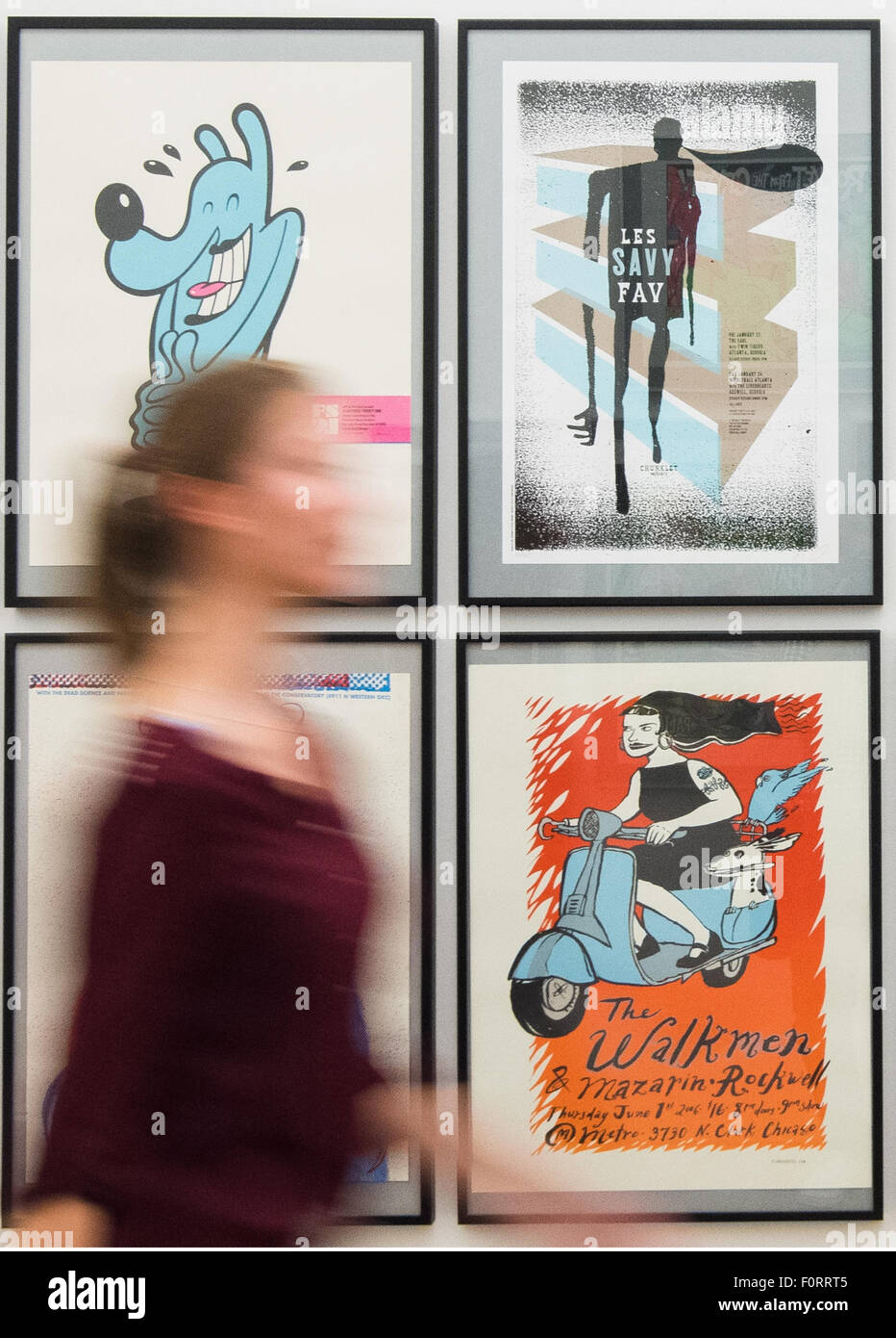 Eine Frau geht vorbei an Plakat während eines Presse-Preview der Ausstellung "Poster Rock Gig Poster und der Flatstock-Konvention" an der Museum Fuer Kunst Und Gewerbe in Hamburg, Deutschland, 20. August 2015. Die Ausstellung läuft bis 01. November zahlreiche Siebdruck Drucke zeigt und Poster gig. Foto: DANIEL BOCKWOLDT/dpa Stockfoto