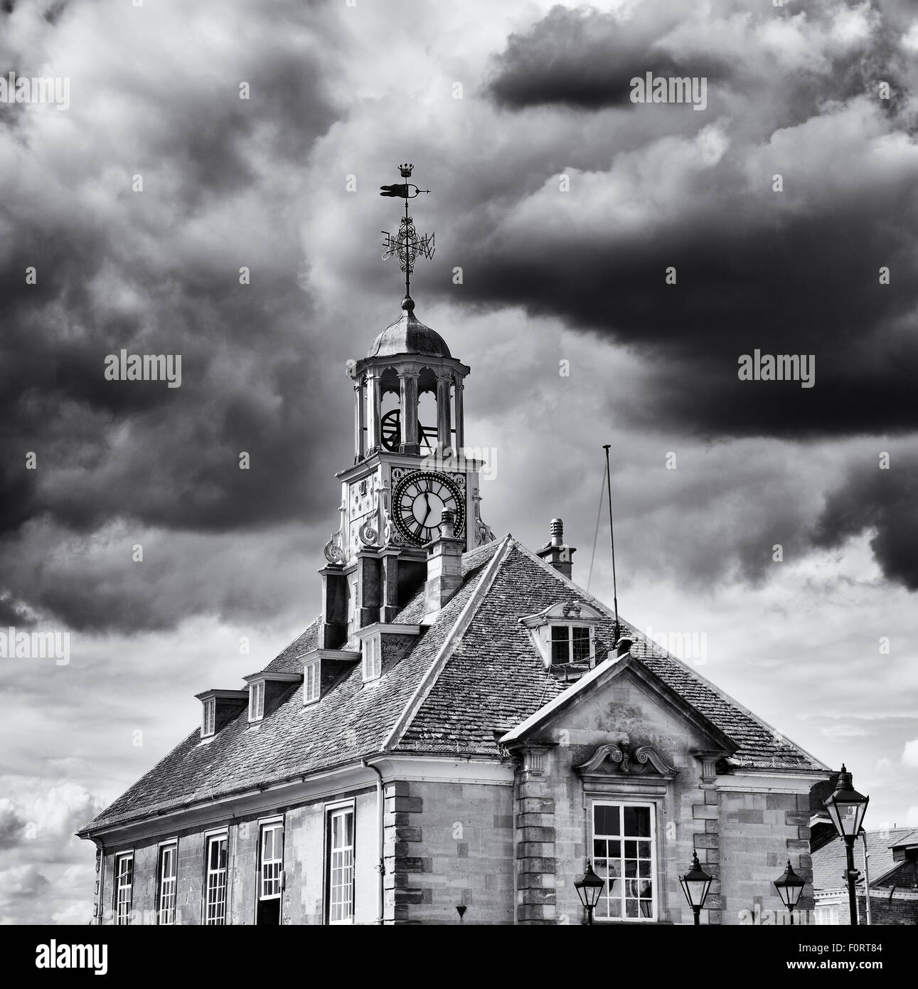 Brackley Rathaus mit Uhrturm gegen stürmischen Wolken. Northamptonshire. England. Schwarz / weiß Stockfoto