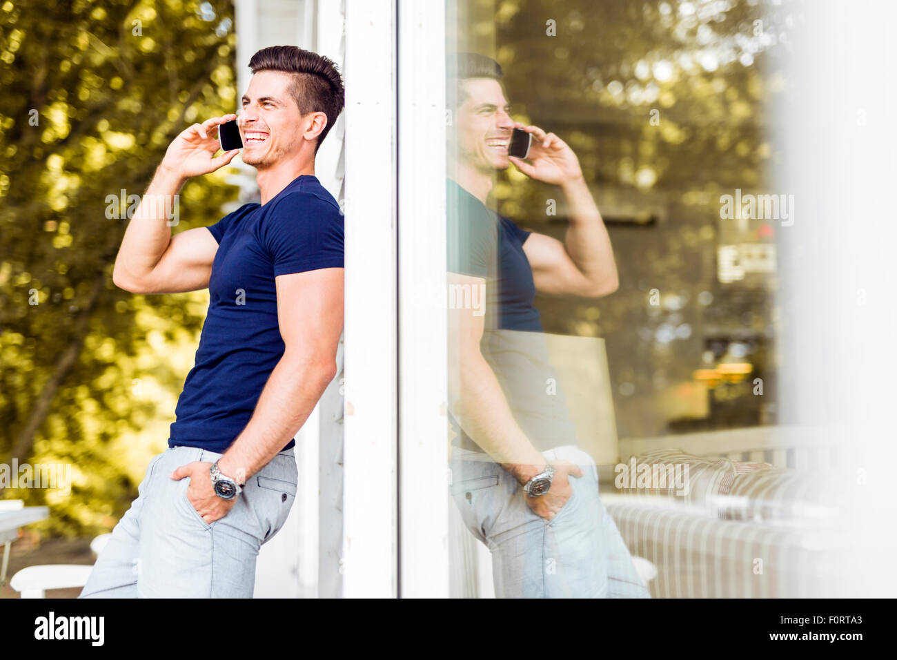 Gut aussehender Mann sprechen auf die Telefon-Natur und sein Spiegelbild ist vorhanden Stockfoto