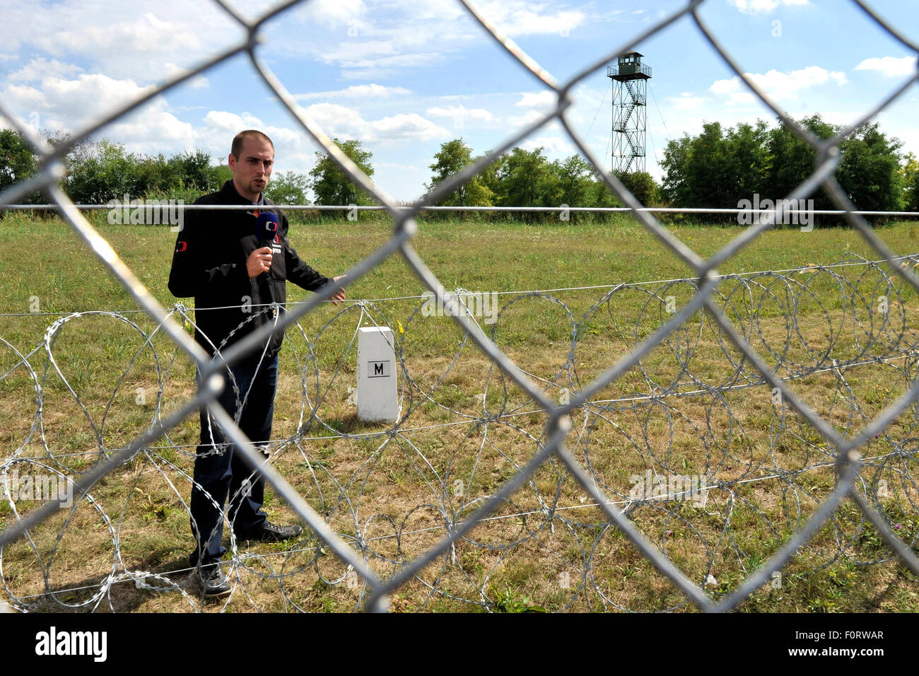 Kubekhaza, Ungarn. 19. August 2015. Tschechische TV-Reporter David Mirejovsky spricht zu den Medien am 19. August 2015, in der Nähe von Kubekhaza, Südungarn, nahe der Grenze zu Serbien und Rumänien. Ungarische Armee und Arbeiter bauen der Wand auf der 175 km lange serbische Grenze zwischen Ungarn und Ungarn auch Pläne für den Bau eines Zauns an der Grenze zu Serbien, Menschen, die illegal in das Land zu stoppen. © Jan Koller/CTK Foto/Alamy Live-Nachrichten Stockfoto