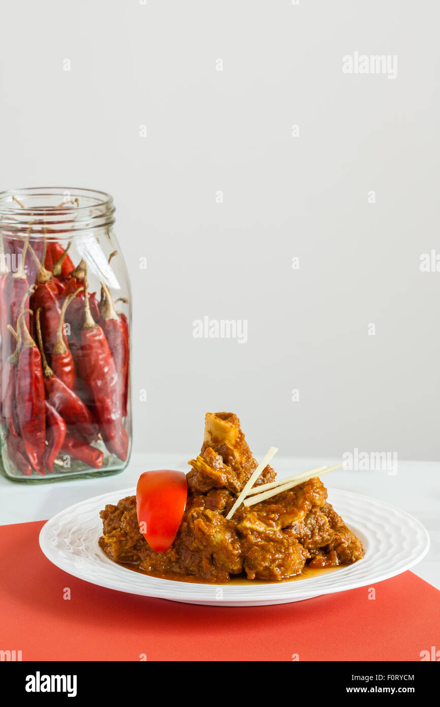 Indische Lamm Rogan Josh mit Beilage (Tomate, Ingwer Julienne) und rote Chili. Diese würzige heißen Kashmiri Gericht hat rote Chilischote. Stockfoto