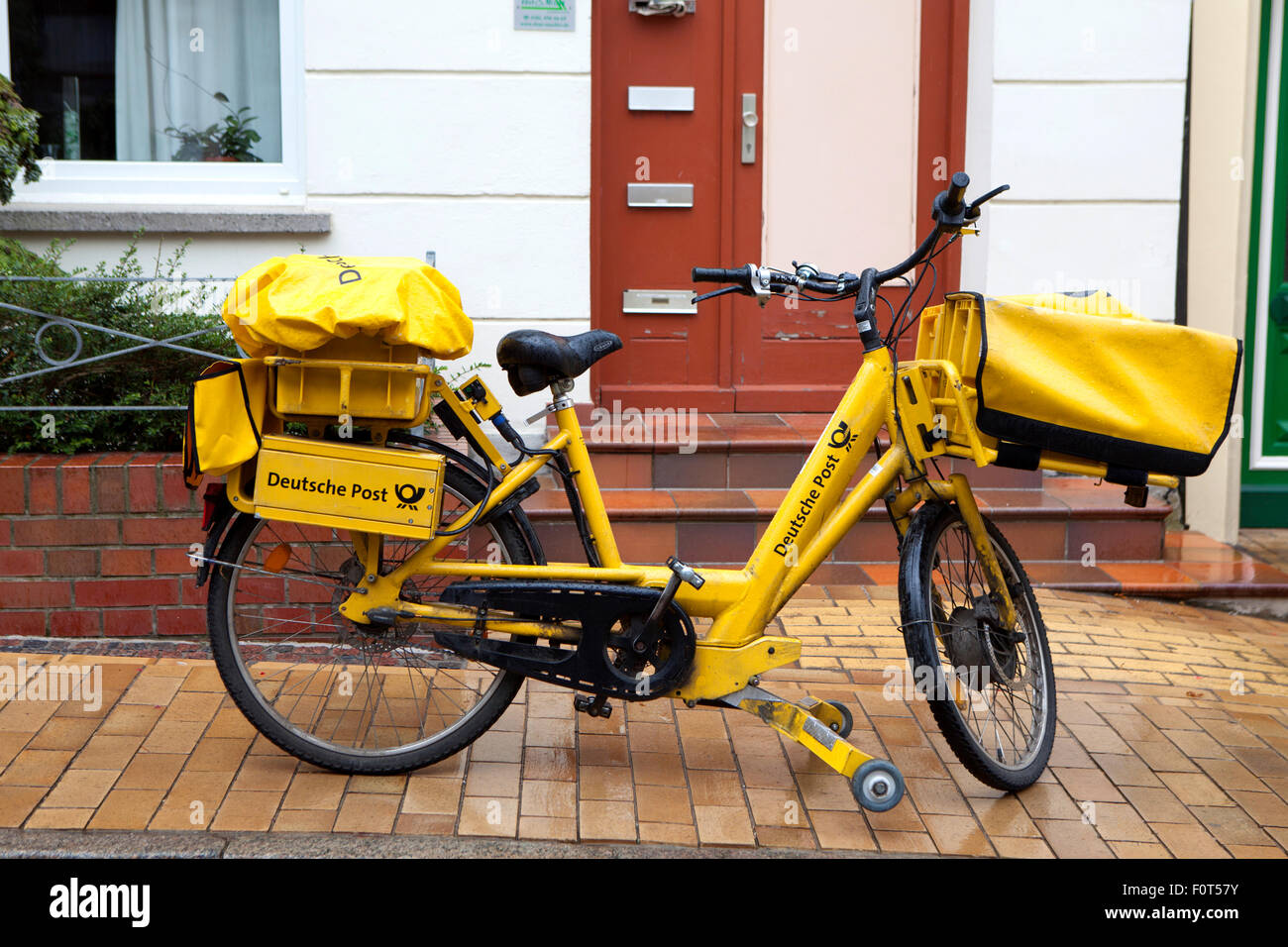 Gelbe Lieferung Fahrrad und Postboten per Deutsche Post