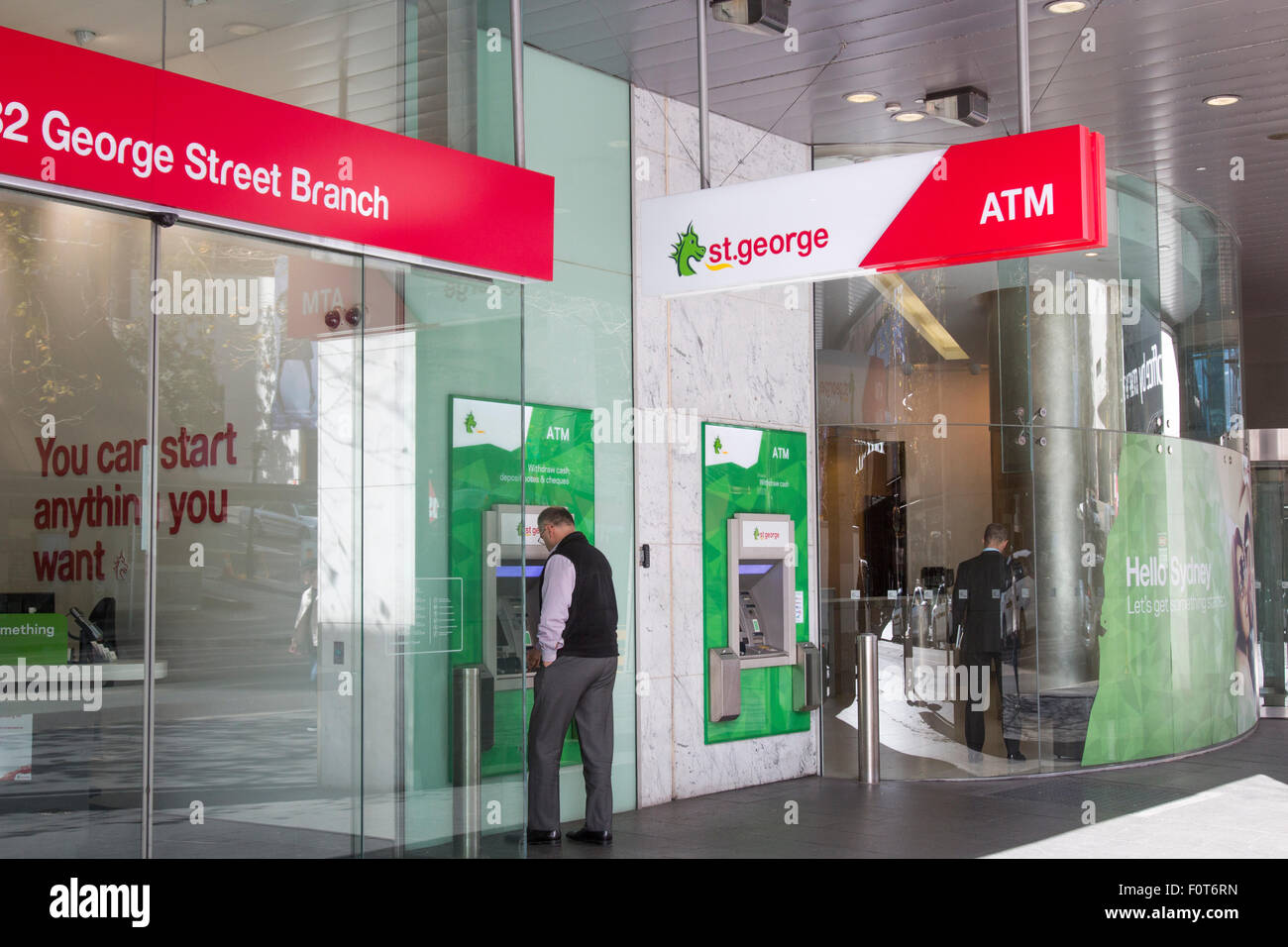 Mann mit einem Geldautomaten ATM am St. George Bank-Filiale im Stadtzentrum von Sydney, Australien Stockfoto