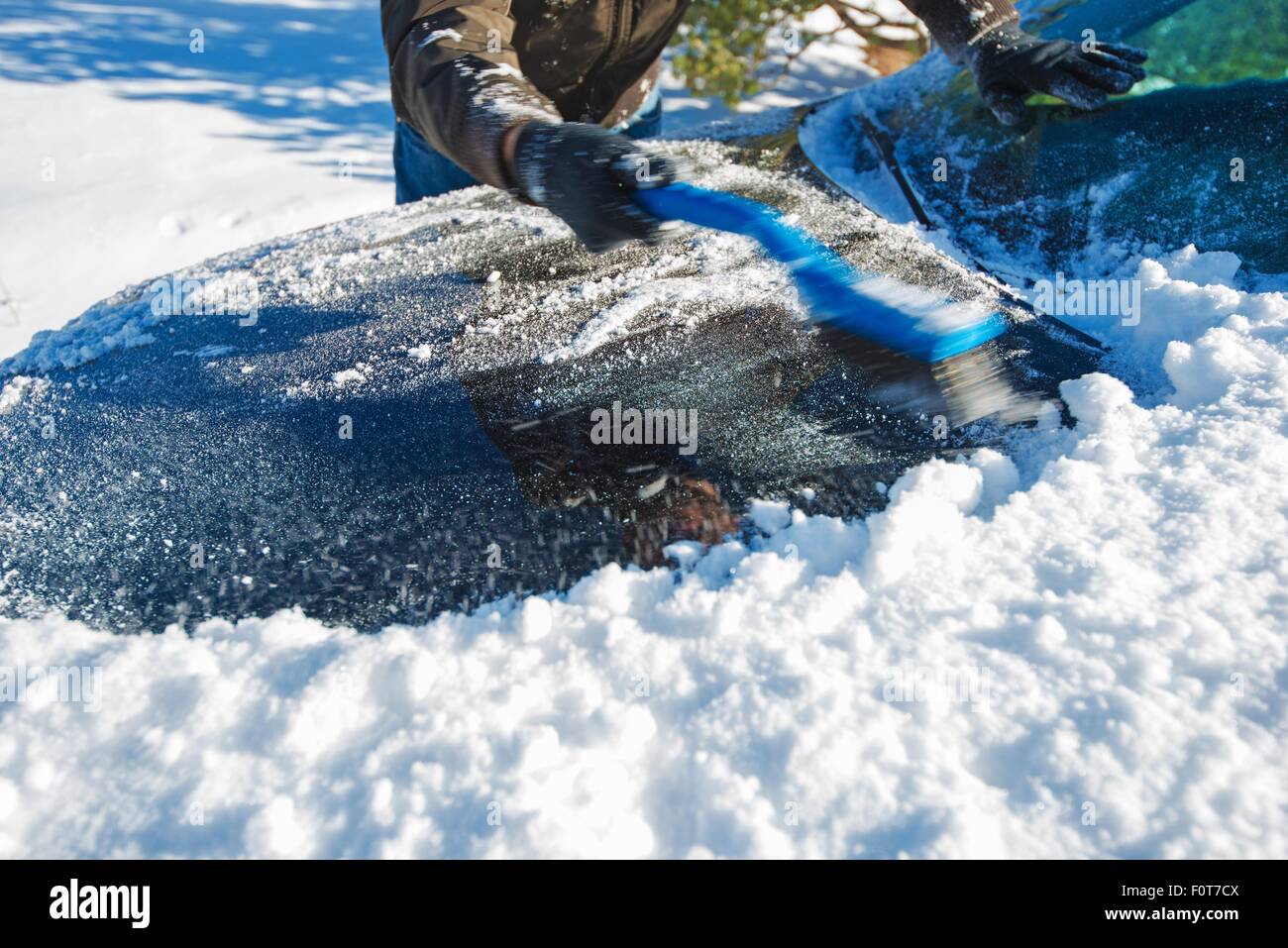 Schneeräumung von Auto. Männer Reinigung Auto aus dem Schnee. Stockfoto