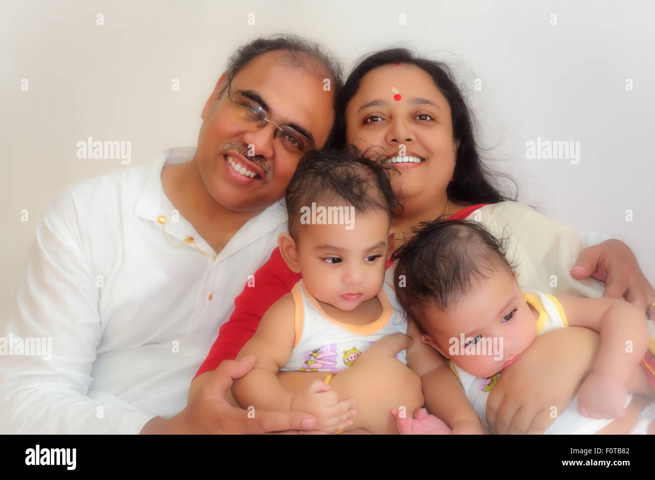 Porträt einer glücklichen Familie Eltern mit Twin Baby Boys zeigen Bindung, Liebe, Zuneigung und Zweisamkeit mit Textfreiraum Stockfoto