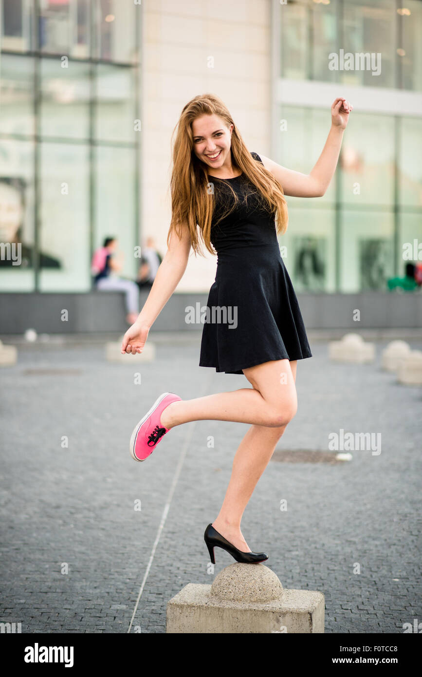 Welche Schuhe zur Auswahl - Teenager auf der Straße einen Fuß in Sneaker und andere in high Heels Stockfoto